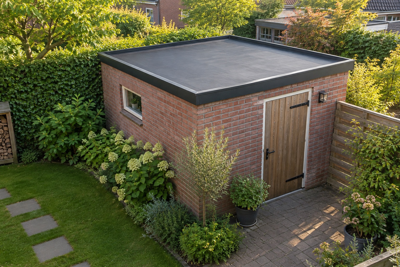 Bakstenen tuinschuur met een houten deur en een zwart plat dak